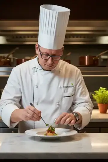 KI-Look Fine-Dining-Koch: Als Sternekoch beim Anrichten im Restaurant.